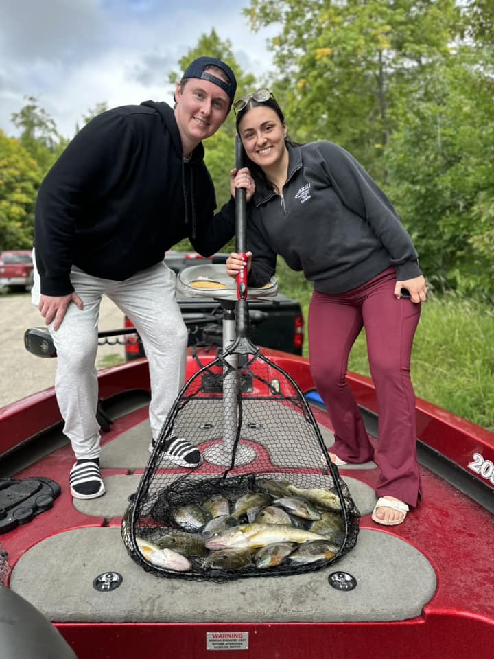 Guide clients with a net full of panfish and walleye after a fishing trip with Cass Lake Area Guide Service.